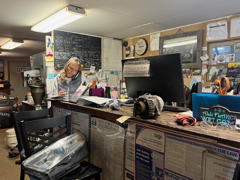Helpful salvage yard team assisting customers with parts searches